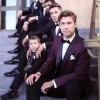 Men and boy sitting on steps in tuxedos